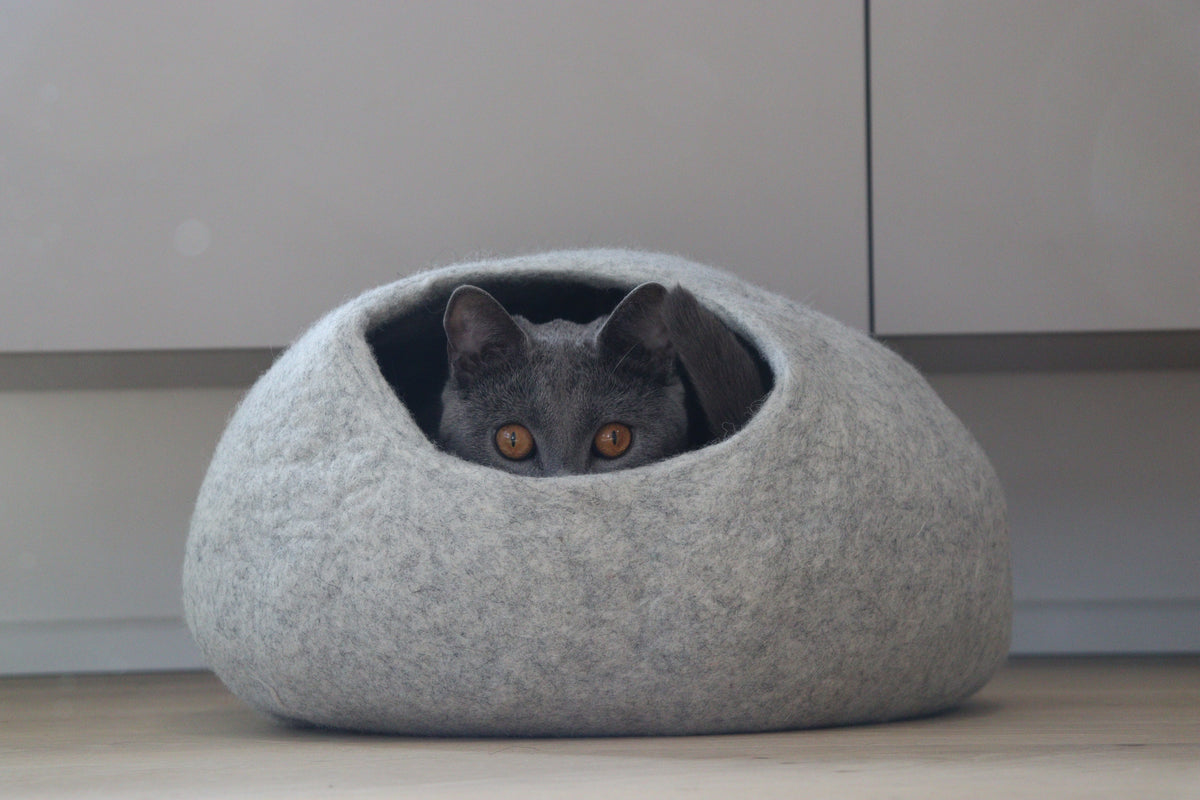 Katze ruht im grauen Nest-Höhlenbett aus Merinofilz