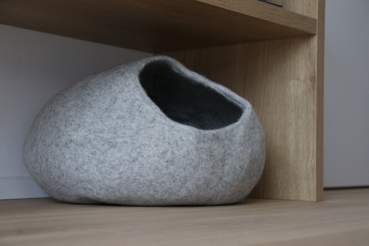 Graues Nest-Katzenbett aus Merinofilz unter einem Holzregal