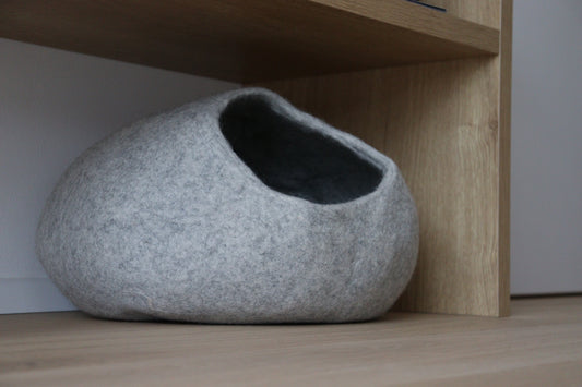 Graues Nest-Katzenbett aus Merinofilz unter einem Holzregal